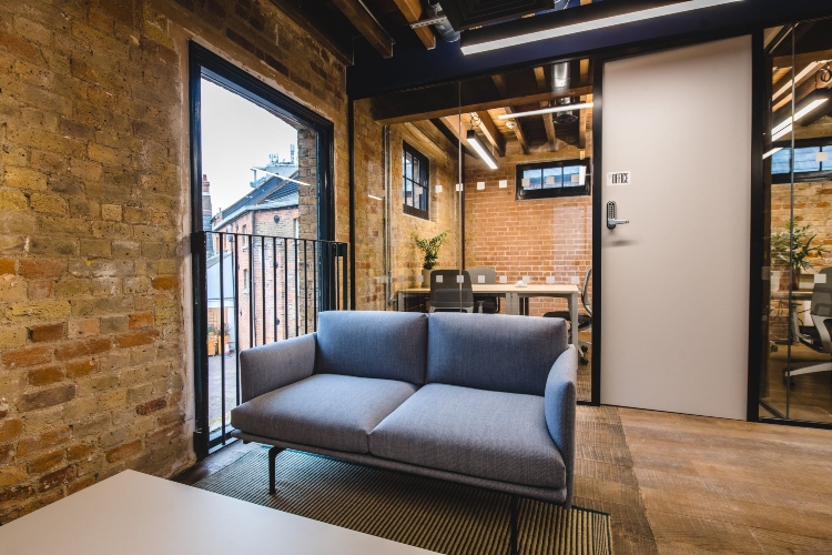  Moderna kancelarija u industrijskom stilu sa zidom od cigle i udobnim nameštajem