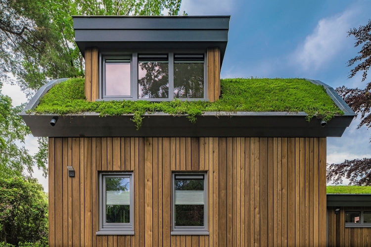 Mala vikendica od drveta i betona ima zeleni krov koji je štiti od svih vremenskih uslova
