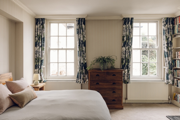 Udobna spavaća soba u tradicionalnom stilu sa cvetnim zavesama i neutralnim zidovima