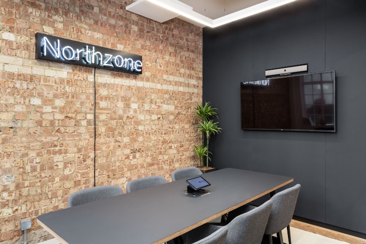  Kancelarijski prostor sa sivim akcentnim zidom, zidom od cigle i sivim nameštajem