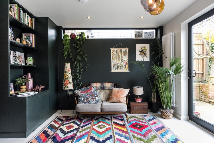  Udobna dnevna soba sa tamnom bojom zidova i šarenim tepihom
