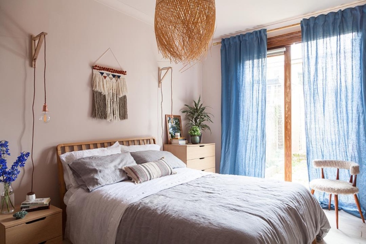  Udobna spavaća soba sa velikim krevetom i plavim zavesama