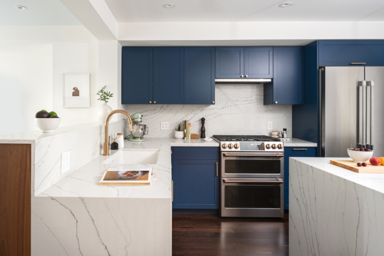  Moderna kuhinja sa ormarićima u tamno plavoj boji i belim radnim pločama