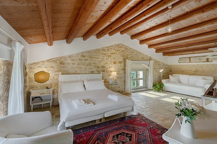 Udobna i prostrana spavaća soba sa drvenim krovom i belim zidovima