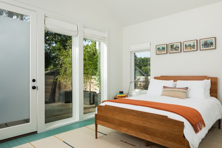 Udobna spavaća soba sa velikim prozorima u kući izgrađenoj u stilu bungalova