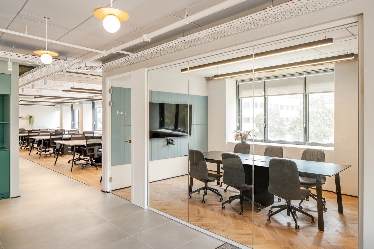 Svetla i udobna kancelarija sa staklenim pregradama koje vizuelnbo proširuju radni prostor