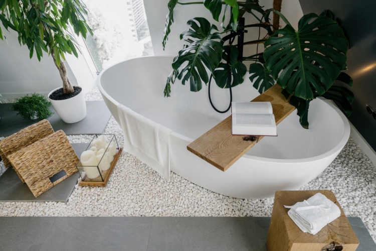 Prirodni dizajn kupatila postignut je zahvaljujući beloj samostojećoj kadi i mnoštvu zelenih biljaka