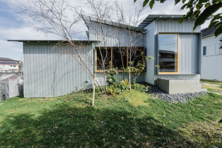 Mala kuća obložena plavim čeličnim pločama: pravi dragulj zelene okoline